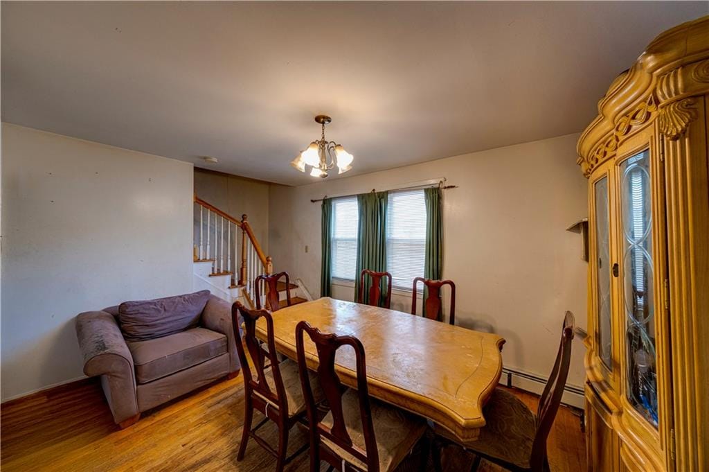 193-32 Williamson Ave, Queens Springfield Gdns, NY 11413 - dining space featuring a baseboard heating unit, stairs, light wood finished floors, a chandelier, and baseboards