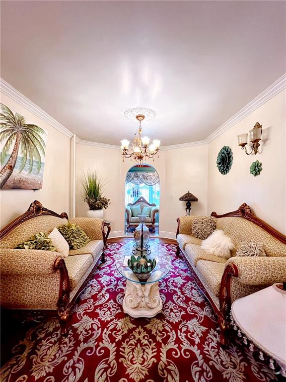 1566 E 46th St, Brooklyn, NY 11234 - living room featuring a chandelier, ornamental molding, baseboards, and wood finished floors