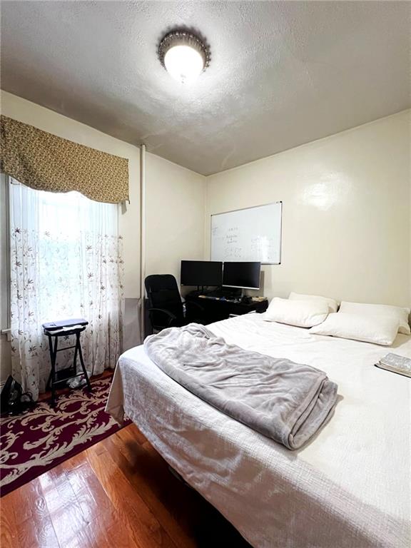 1566 E 46th St, Brooklyn, NY 11234 - bedroom featuring wood finished floors and a textured ceiling