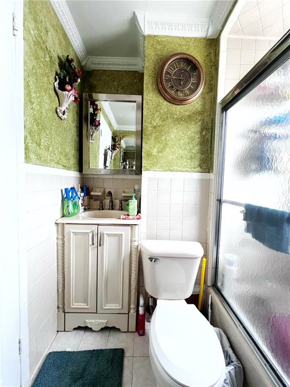 1566 E 46th St, Brooklyn, NY 11234 - full bathroom with tile walls, tile patterned flooring, crown molding, vanity, and toilet