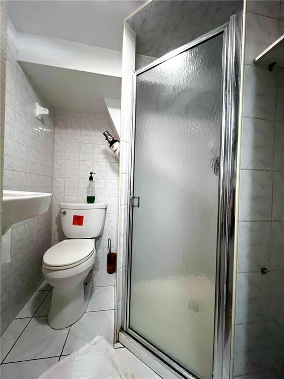 1566 E 46th St, Brooklyn, NY 11234 - bathroom featuring toilet, a stall shower, and tile walls