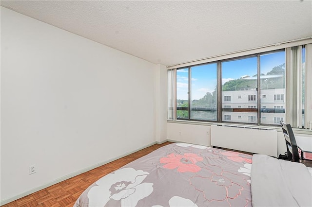 755 Narrows Rd N Unit 602, Staten Island, NY 10304 - unfurnished bedroom featuring baseboards, a textured ceiling, and radiator