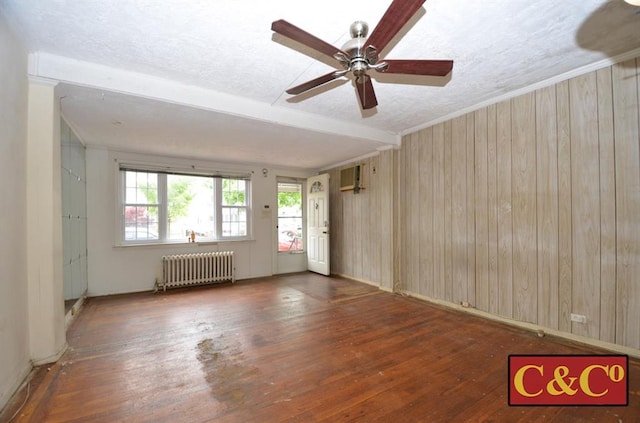 1927 E 34th St, Brooklyn, NY 11234 - spare room featuring radiator, hardwood / wood-style floors, wood walls, a ceiling fan, and a textured ceiling