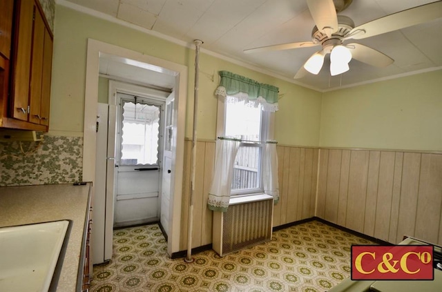1927 E 34th St, Brooklyn, NY 11234 - kitchen with a sink, a wainscoted wall, brown cabinetry, crown molding, and wood walls