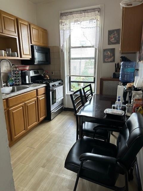1181 Bushwick Ave, Brooklyn, NY 11221 - kitchen featuring gas range, black microwave, decorative backsplash, open shelves, and brown cabinets