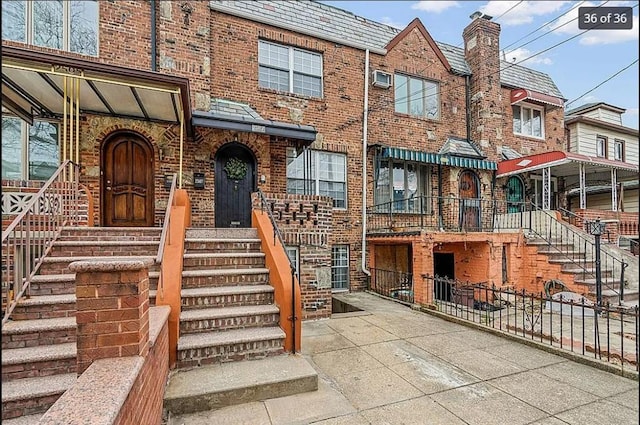 2507 E 23rd St, Sheepshead Bay, NY 11235 - doorway to property featuring brick siding, a high end roof, and a chimney