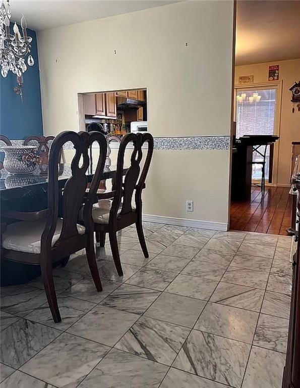 2054 Richomond Ave, New Springville, NY 10314 - dining space with light marble finish flooring, a chandelier, and baseboards