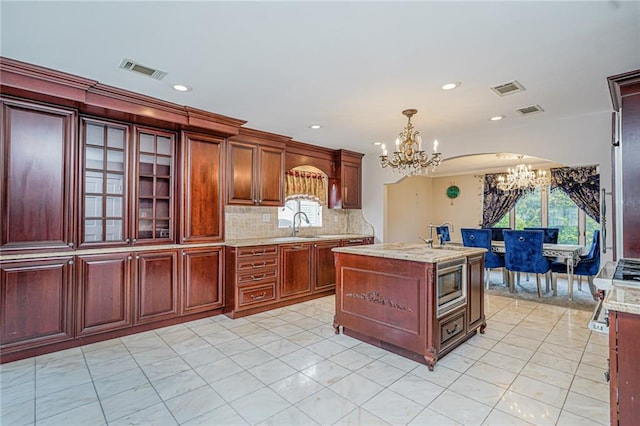 284 Todt Hill Rd, Staten Island, NY 10314 - kitchen featuring a chandelier, stainless steel microwave, pendant lighting, dark brown cabinets, and glass insert cabinets