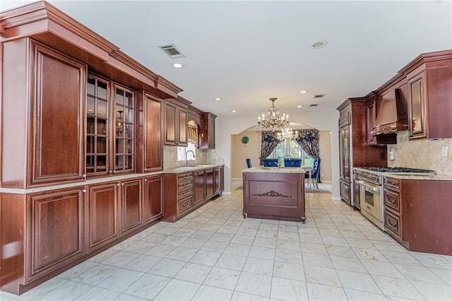 284 Todt Hill Rd, Staten Island, NY 10314 - kitchen with range with two ovens, premium range hood, a chandelier, recessed lighting, and glass insert cabinets