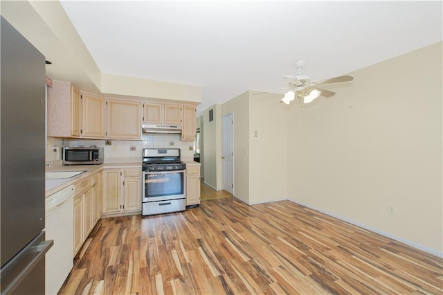 88 Jumel St, Staten Island, NY 10308 - kitchen featuring stainless steel appliances, under cabinet range hood, light countertops, light wood-style floors, and backsplash