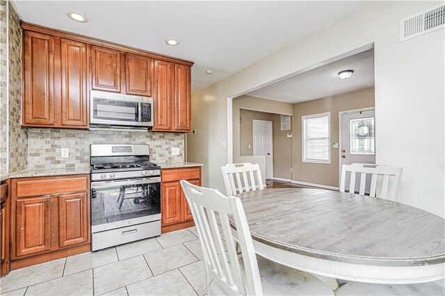 483 Van Duzer St, Staten Island, NY 10301 - kitchen featuring appliances with stainless steel finishes, brown cabinets, tasteful backsplash, and recessed lighting