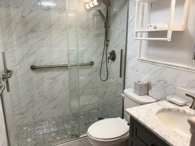 9977 Shore Rd Unit 11C, Brooklyn, NY 11209 - bathroom with vanity, a shower stall, and tile walls