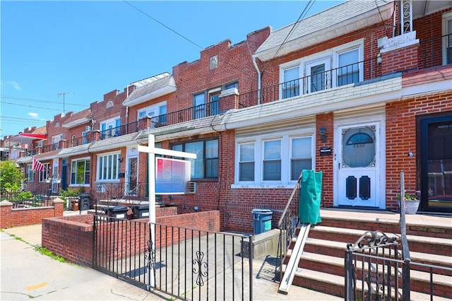 8669 15th Ave, Brooklyn, NY 11228 - townhome / multi-family property with brick siding, a fenced front yard, and a residential view