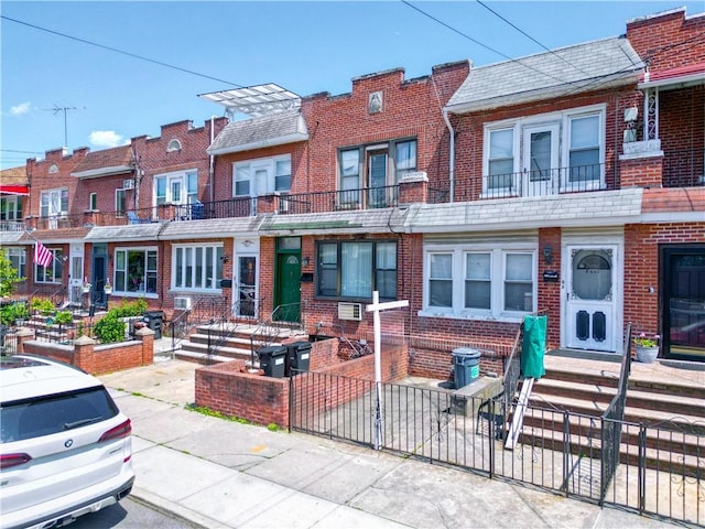 8669 15th Ave, Brooklyn, NY 11228 - multi unit property with brick siding, a fenced front yard, and entry steps