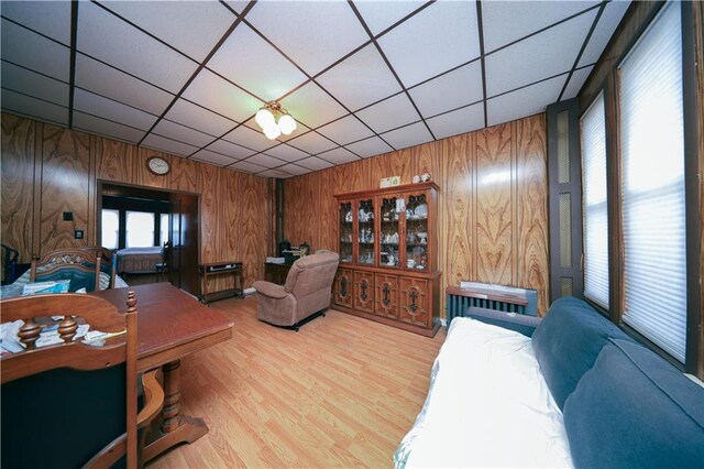 8669 15th Ave, Brooklyn, NY 11228 - living room with wood walls, a drop ceiling, and wood finished floors