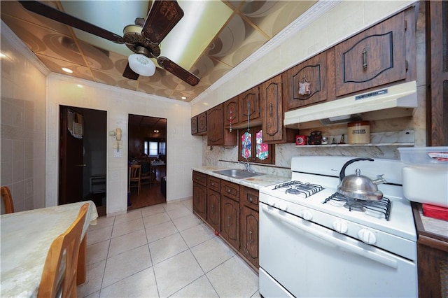 8669 15th Ave, Brooklyn, NY 11228 - kitchen featuring white gas stove, under cabinet range hood, light countertops, light tile patterned floors, and a ceiling fan
