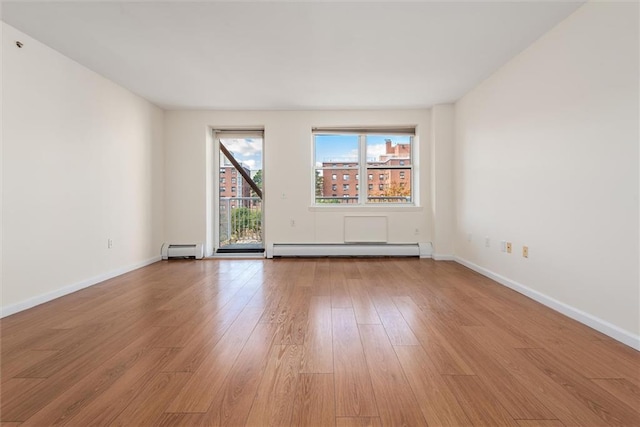 221 Bch 80th St Unit 4F, Rockaway Beach, NY 11693 - unfurnished room featuring a baseboard heating unit, light wood finished floors, and baseboards