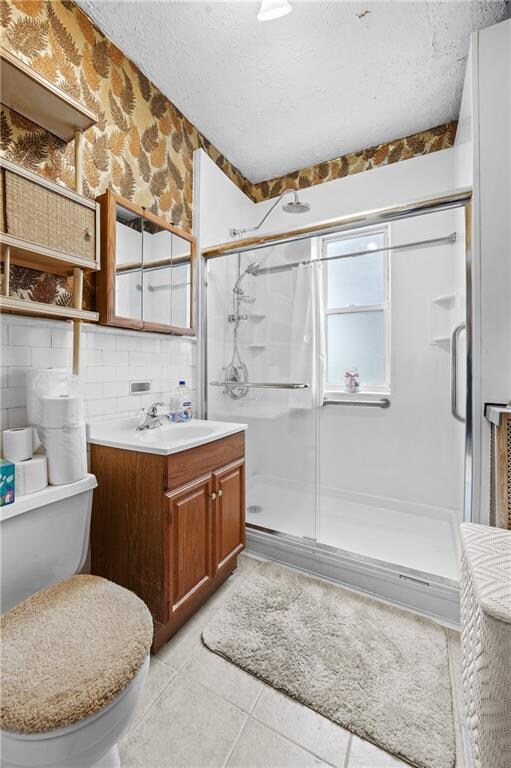 1640 W 1st St, Brooklyn, NY 11223 - full bath featuring a shower stall, vanity, toilet, tile patterned floors, and a textured ceiling