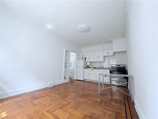 219 78th St Unit 2D, Brooklyn, NY 11209 - kitchen featuring freestanding refrigerator, stainless steel stove, white cabinetry, backsplash, and light countertops
