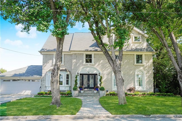 5 Haywood St, Staten Island, NY 10307 - view of front of house with french doors, an attached garage, brick siding, a front lawn, and driveway
