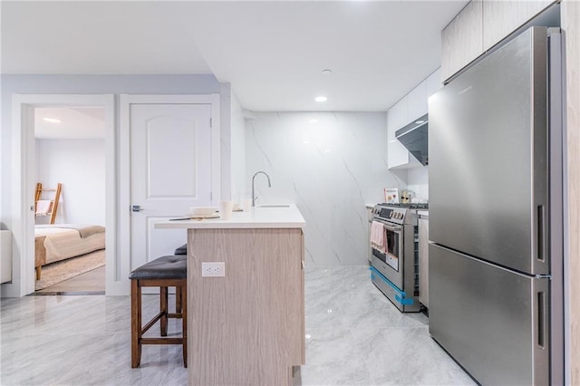 811 45th St Unit 5B, Brooklyn, NY 11220 - kitchen with appliances with stainless steel finishes, a sink, a breakfast bar area, modern cabinets, and light countertops