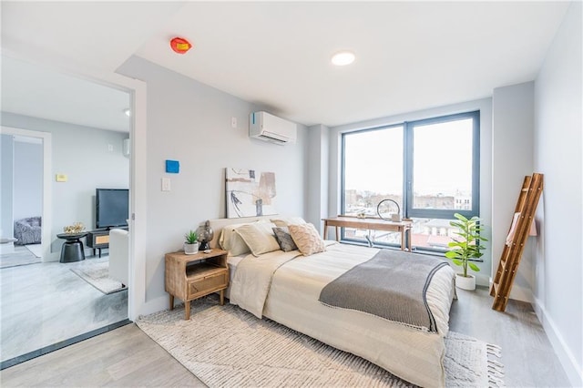 811 45th St Unit 5B, Brooklyn, NY 11220 - bedroom featuring a wall unit AC, light wood-style flooring, and baseboards