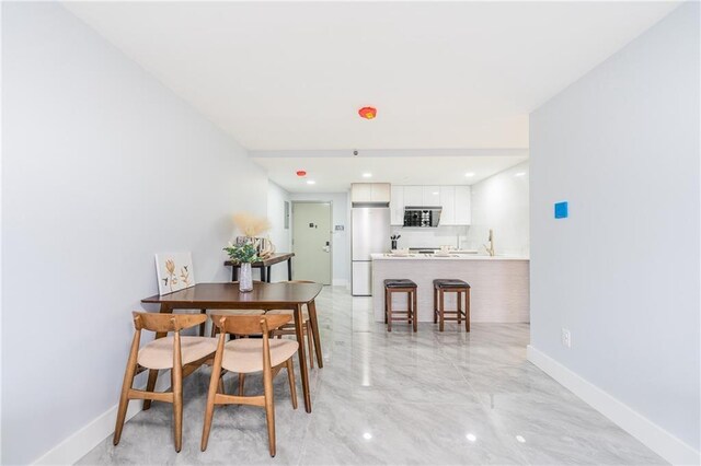 811 45th St Unit 5B, Brooklyn, NY 11220 - dining area featuring light marble finish flooring and baseboards