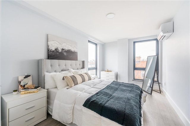 811 45th St Unit 5B, Brooklyn, NY 11220 - bedroom with a wall mounted AC, light wood-type flooring, and baseboards