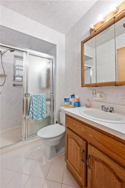 1347 E 57th St, Brooklyn, NY 11234 - bathroom with vanity, tile patterned floors, a shower stall, and toilet
