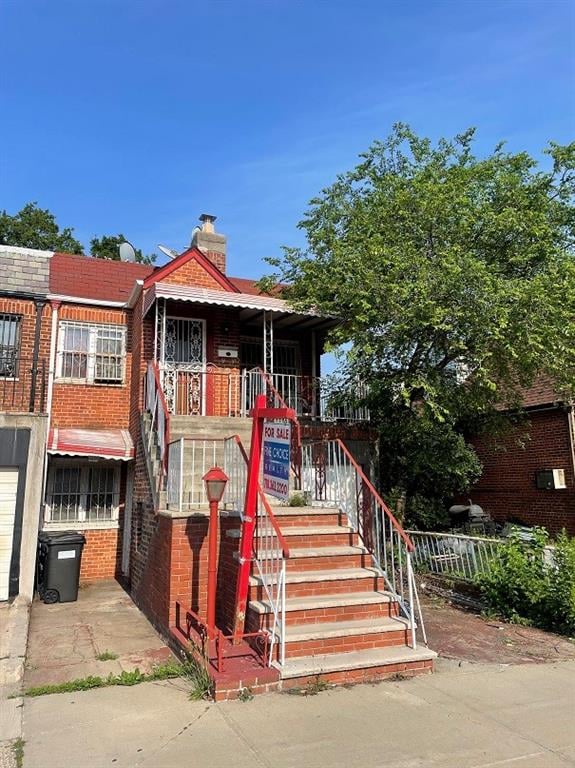 4555 Kings Hwy, Brooklyn, NY 11234 - view of front of house with stairway, a porch, a chimney, and brick siding