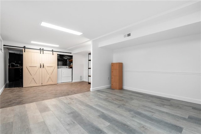 41 Bent St, Staten Island, NY 10312 - below grade area with a barn door, wood finished floors, and washing machine and dryer