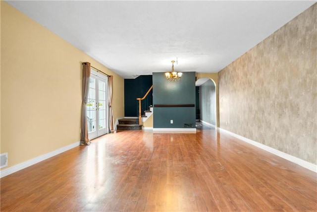 41 Bent St, Staten Island, NY 10312 - empty room featuring wood finished floors, arched walkways, a chandelier, and stairs