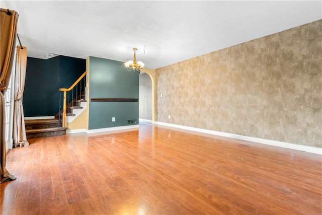 41 Bent St, Staten Island, NY 10312 - spare room with wood finished floors, a chandelier, arched walkways, and stairs