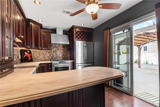 41 Bent St, Staten Island, NY 10312 - kitchen with wall chimney range hood, appliances with stainless steel finishes, light countertops, tasteful backsplash, and dark wood-type flooring
