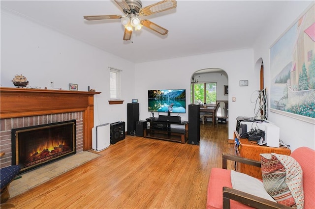 4070 Victory Blvd, Staten Island, NY 10314 - living room featuring ceiling fan, light wood finished floors, arched walkways, and a brick fireplace