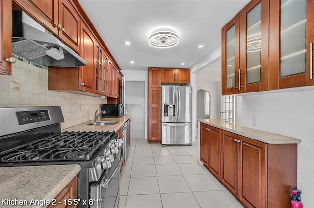 2160 E 36th St, Brooklyn, NY 11234 - kitchen with stainless steel appliances, under cabinet range hood, tasteful backsplash, light tile patterned floors, and glass insert cabinets
