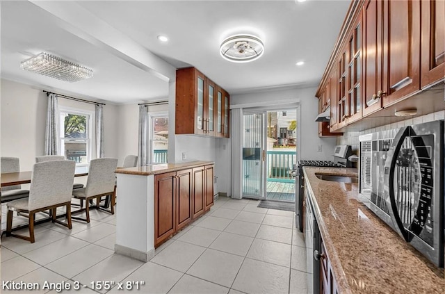 2160 E 36th St, Brooklyn, NY 11234 - kitchen with glass insert cabinets, light stone counters, healthy amount of natural light, brown cabinetry, and recessed lighting