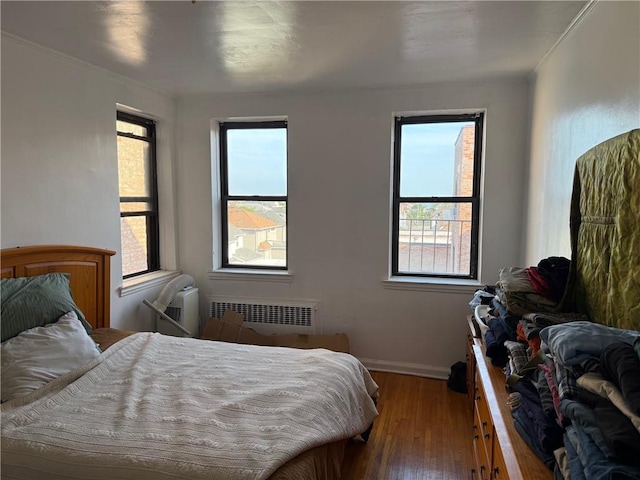 128-11 Newport Ave Unit 4C, Queens, NY 11694 - bedroom featuring radiator heating unit, hardwood / wood-style floors, multiple windows, and ornamental molding