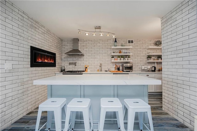 675 Ocean Ave Unit 5J, Long Branch, New Jersey, NJ 07740 - bar featuring wall chimney range hood, brick wall, and a glass covered fireplace