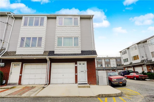 61 Avon Ln, Staten Island, NY 10314 - view of property featuring brick siding and a garage