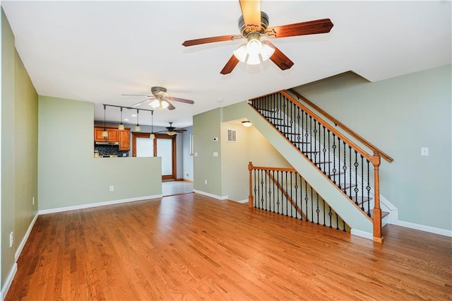 61 Avon Ln, Staten Island, NY 10314 - unfurnished living room with a ceiling fan, light wood-style flooring, and stairs