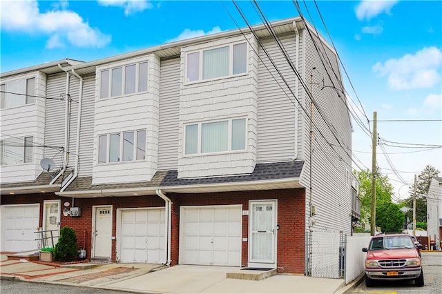 61 Avon Ln, Staten Island, NY 10314 - view of property with brick siding, an attached garage, and a shingled roof