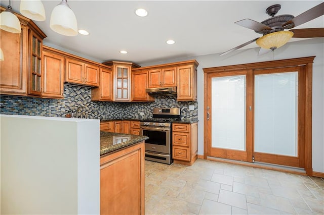 61 Avon Ln, Staten Island, NY 10314 - kitchen with stainless steel range with gas stovetop, brown cabinetry, under cabinet range hood, decorative backsplash, and a ceiling fan