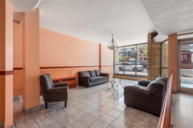 735 Avenue W Unit 6J, Brooklyn, NY 11223 - living room with radiator heating unit, a wainscoted wall, a decorative wall, and light tile patterned floors