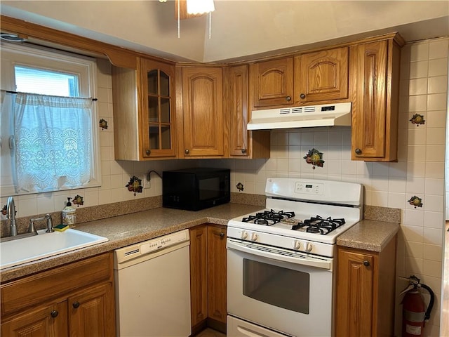 30 Regis Dr Unit 76, Staten Island, NY 10314 - kitchen with white appliances, under cabinet range hood, brown cabinetry, decorative backsplash, and glass insert cabinets