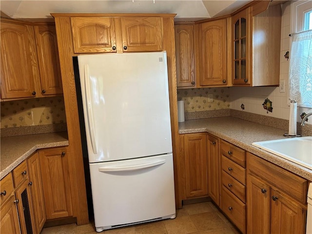 30 Regis Dr Unit 76, Staten Island, NY 10314 - kitchen with freestanding refrigerator, glass insert cabinets, brown cabinetry, and light countertops