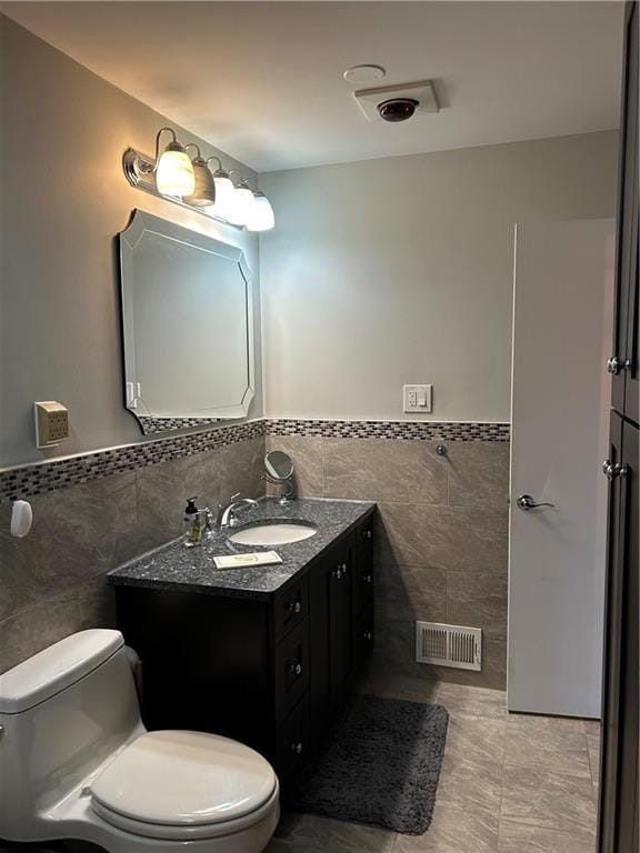 30 Regis Dr Unit 76, Staten Island, NY 10314 - bathroom with tile walls, vanity, wainscoting, and tile patterned flooring