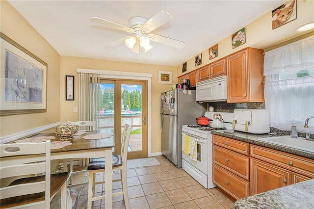 46 Mosely Ave, Staten Island, NY 10312 - kitchen with white appliances, brown cabinetry, ceiling fan, and light tile patterned floors