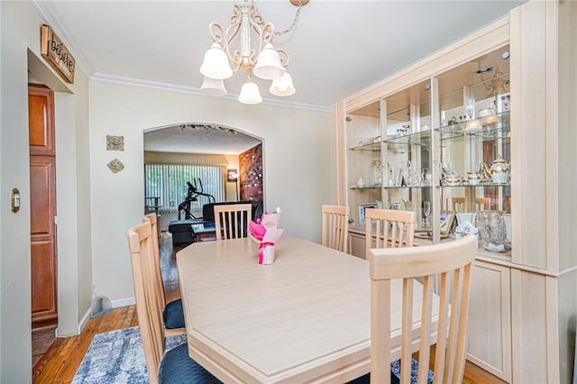 46 Mosely Ave, Staten Island, NY 10312 - dining room featuring a chandelier, light wood-style flooring, arched walkways, and crown molding