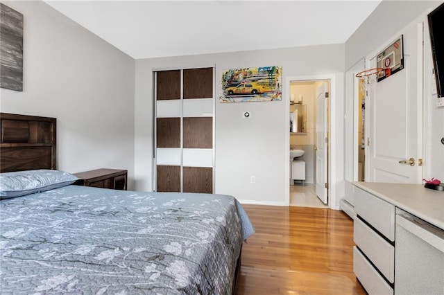 135 28th Ave Unit 2A, Brooklyn, NY 11214 - bedroom with wood finished floors, a baseboard heating unit, and a closet
